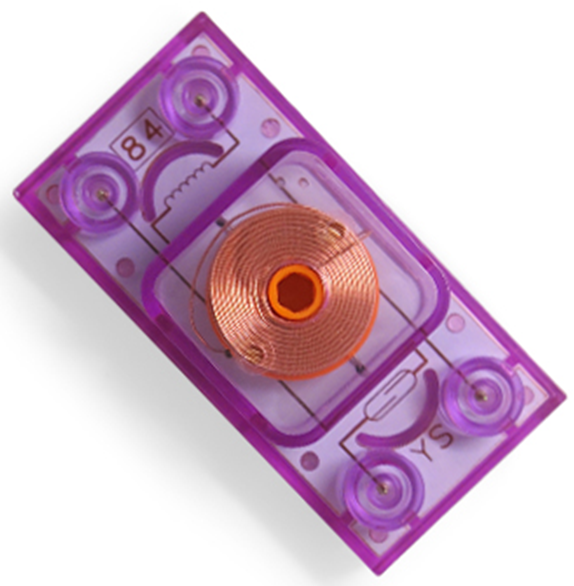 A transparent, purple rectangular object featuring a central copper coil, identified as the Inductor Block - E-Blox® by E-Blox. This component has circular patterns on the corners and is marked with "84" on the top left and "Y5" on the bottom right.