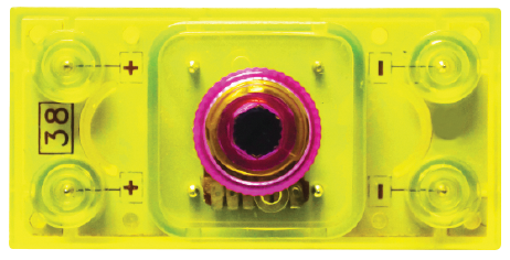 The Volume Control Block for Circuit Builder by E-Blox features a rectangular, yellow transparent plastic casing with a centrally-located, cylindrical metallic component. The left side marked with "38" and the corners show plus and minus signs, indicating positive and negative terminals. Ideal for anyone looking for precise volume control in their circuits.