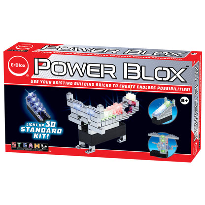 A red and white box labeled "Power Blox™ Standard Set - E-Blox® Student Set" contains a light-up 3D building kit from E-Blox. Utilizing patented technology, the box features images of possible constructions, such as a spaceship and a tower. Suitable for ages 8 and up, it encourages creativity with existing building bricks.