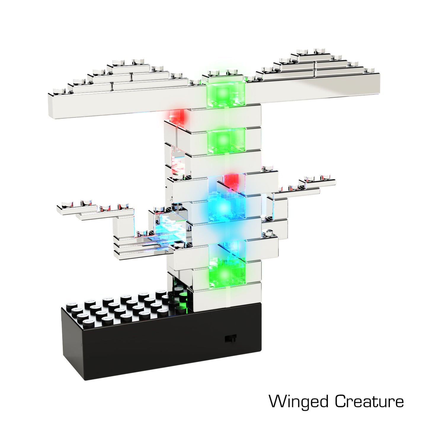 A block structure created using the Power Blox™ Standard Set - E-Blox® Student Set from E-Blox, featuring translucent bricks that illuminate in multiple colors. Assembled to resemble a winged creature, it utilizes patented technology with a black rectangular base and includes red, green, and blue illuminated bricks. Text in the image reads "Winged Creature.