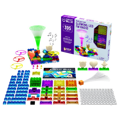 Image of a Circuit Blox™ 395 Project Classroom Set by E-Blox® with glowing LED FM radio functionality and 395 engaging projects. The kit features colorful interlocking blocks, various electronic components, a base grid, an instruction booklet adhering to NGSS requirements, and completed project examples. The background showcases the box packaging.