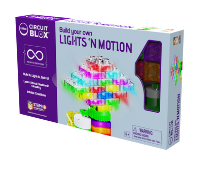 A box featuring vibrant circuits and LED components is labeled "Circuit Blox™ Lights 'n Motion- Classroom Set" by E-Blox. The packaging displays a 3D circuit structure and highlights educational play suitable for children aged 5 and up. STEM.org certified, it includes a choking hazard warning and fits perfectly into the STEM curriculum.