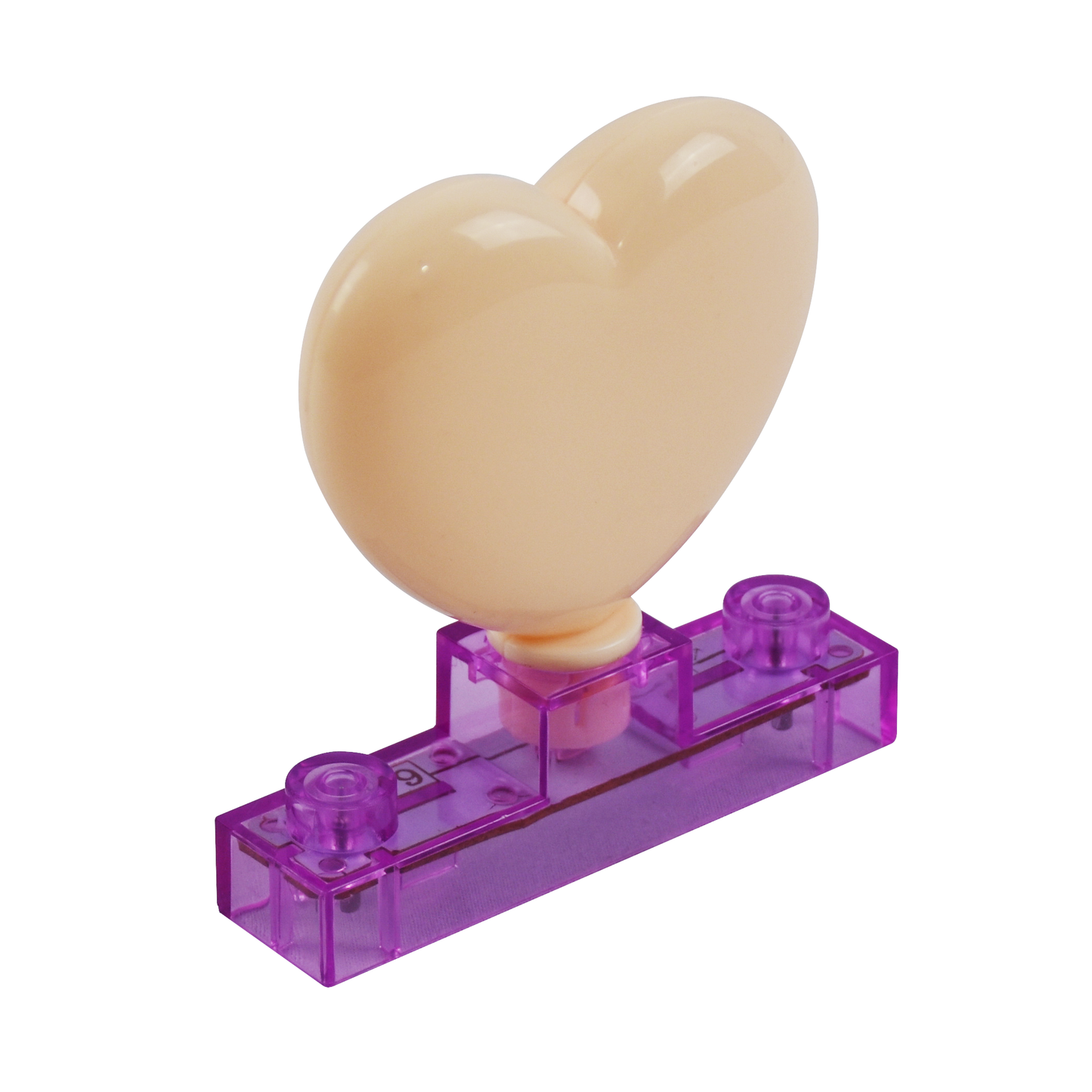 A cream-colored, heart-shaped component is attached to a small, rectangular, translucent purple base with two circular connectors on top. This piece, resembling a toy or building block component, can be part of the Circuit Blox™ 59 project Student Set by E-Blox®, which encourages STEM learning and meets NGSS requirements.