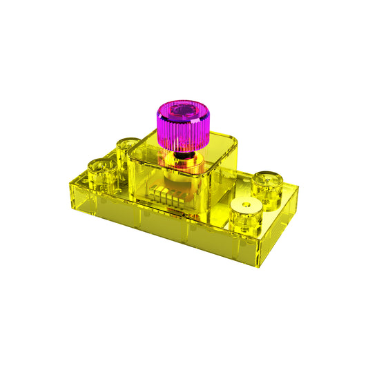 A small, transparent yellow rectangular plastic piece with three protruding cylindrical elements. The central cylinder is topped with a transparent pink knob-like structure, resembling an E-Blox Volume Control Block for Circuit Builder toys. The background is plain white.