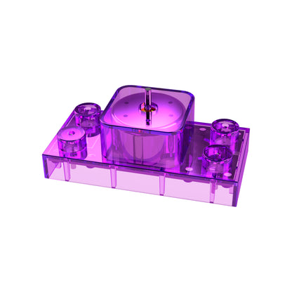 The Circuit Blox™ - Motor Block - E-Blox® by E-Blox is a futuristic and geometric translucent purple plastic device featuring a rectangular base with rounded corners and four cylindrical compartments. The central compartment houses a visible brass pin, reminiscent of the design elements seen in Circuit Blox.