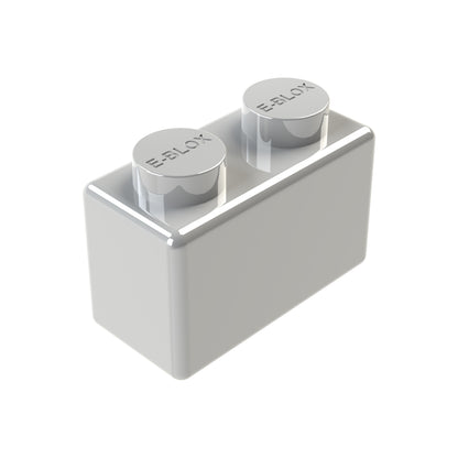 A gray, rectangular 1x2 Block from E-Blox has two cylindrical pegs on top and is embossed with the brand name. Made of conductive tin, this versatile piece is part of a set that comes in seven colors.