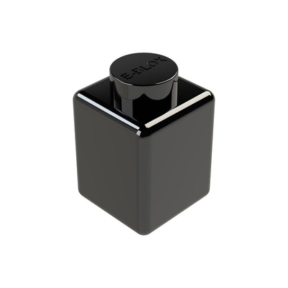 A sleek, black E-Blox 1x1 Block ink bottle features a cube shape with a round cap indented with the brand's logo. This modern design has a reflective surface and is available in seven different colors.