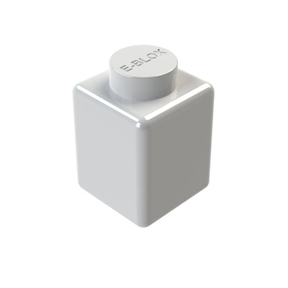 A single E-Blox 1x1 white glossy building block with conductive tin and a round top expands into 7 vibrant colors, reflecting light off its smooth edges.