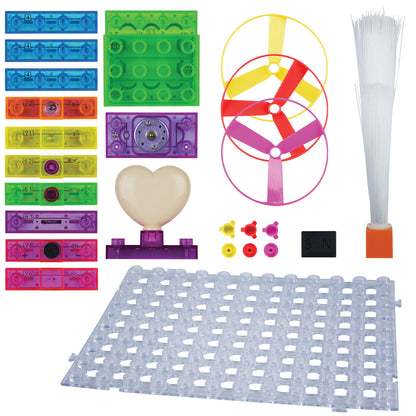 A variety of colorful components from the Circuit Blox™ 59 - E-Blox® Circuit Board Building Blocks Toys by E-Blox are laid out. These include transparent plastic building blocks, two colorful propeller-style discs, a grid board, a heart-shaped piece, small electronic components for electricity experiments, and a fiber optic light perfect for building projects.