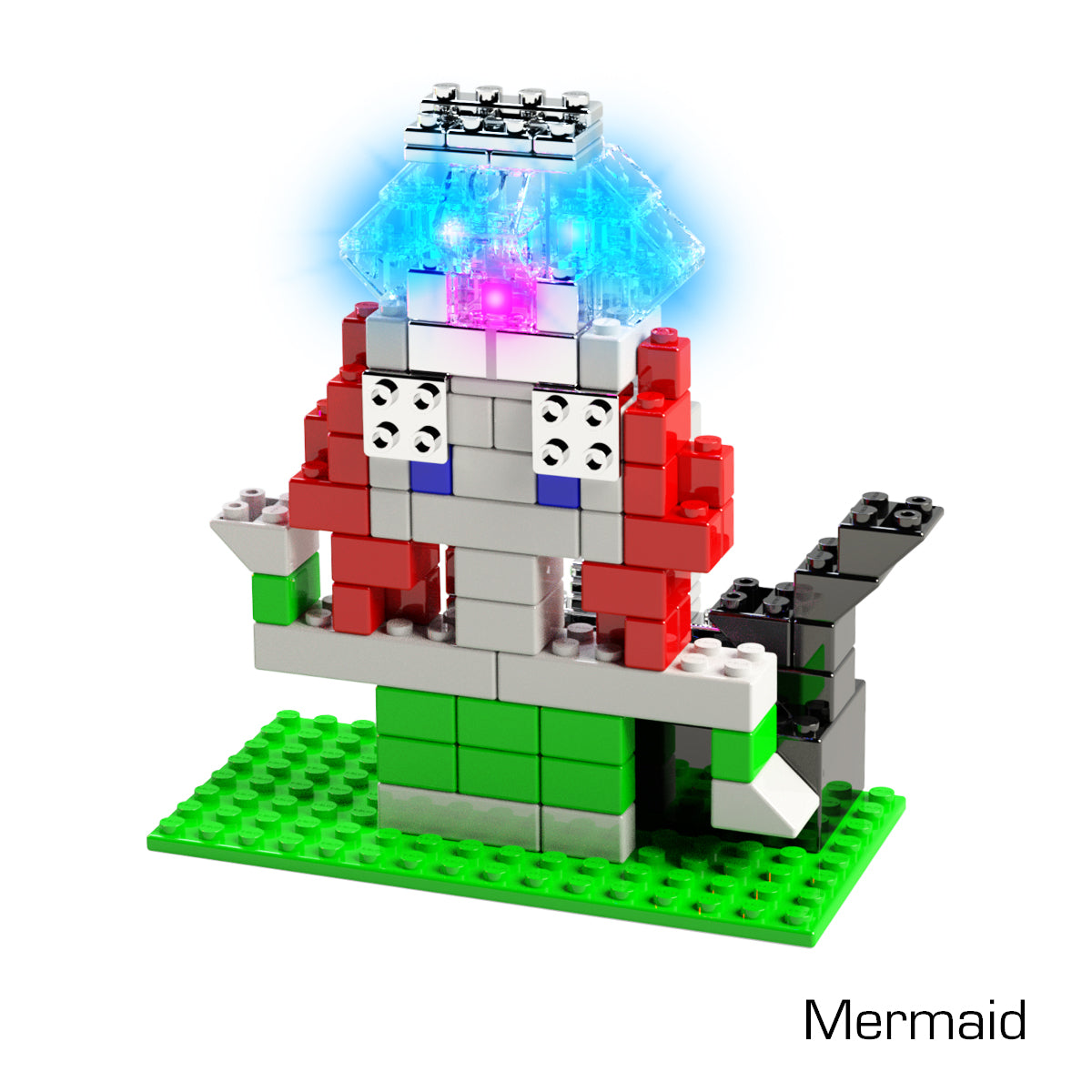 A vibrant, blocky, pixelated mermaid figure built from interlocking plastic bricks stands on a green baseplate. This toy brick set features a grey tail, red and white torso, green lower body, and a blue-transparent head illuminated by blue and purple LED lights. Text reads "Mermaid." This creation is part of the Power Blox™ Builds Deluxe Set by E-Blox® LED Light-Up Building Blocks from E-Blox.