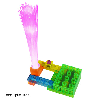 A vibrant fiber optic tree with pink lights is integrated into a colorful base constructed from transparent interlocking bricks in green, blue, and orange. The text "Fiber Optic Tree" appears in the lower left corner. This mesmerizing creation can be further enhanced using E-Blox's Circuit Blox™ BYO Flying Saucer Circuit Board Building Blocks Toys for an interactive experience.