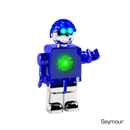 A blue humanoid robot toy with a shiny metallic finish is shown. It has a green glowing circular element on its chest and is wearing a helmet with a visor. The toy's right hand is raised. The name "LUMEN®- Seymour - Illuminated Mini Figure" from the E-Blox, Inc. Mini PowerFigure™ series is written at the bottom right of the image.