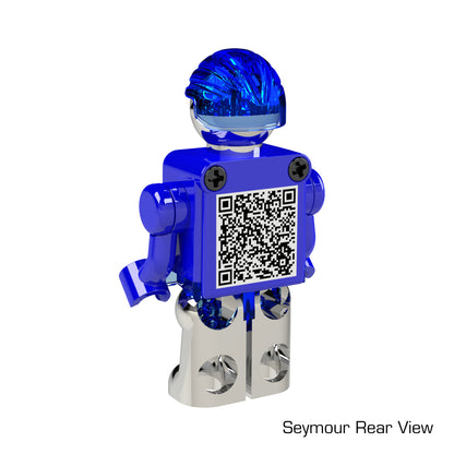 A transparent blue and silver LUMEN®- Seymour - Illuminated Mini Figure by E-Blox, Inc. is shown from the rear. The figure has a QR code on its back and the label "Seymour Rear View" is visible in the bottom right corner of the image.