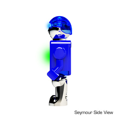 A side view of a small, blue LUMEN® - Seymour - Illuminated Mini Figure by E-Blox, Inc. with a transparent helmet and glowing light on its upper body. The figure stands upright on two legs, with its left arm extended downward. The text "Seymour Side View" is visible in the bottom right corner.