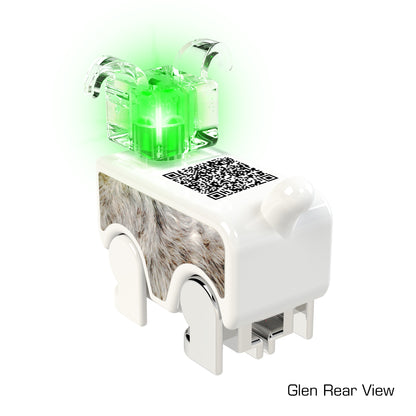 A small, white LUMEN®- Glen- Illuminated Mini Figure by E-Blox, Inc. features a QR code on its back. This electronic device has glowing green LUMEN lights on top and is positioned on what appear to be four legs. The text "Glen Rear View" is present in the bottom right corner.