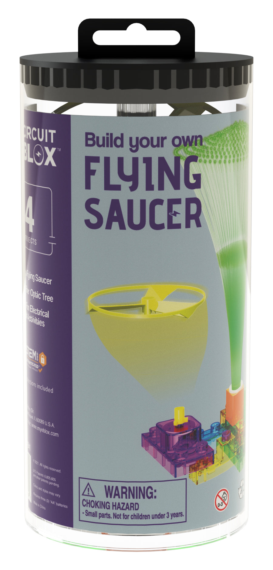 A cylindrical packaging showcases the Circuit Blox™ BYO Flying Saucer Circuit Board Building Blocks Toys by E-Blox. The text reads "Build your own Flying Saucer." The image displays components such as a fan blade, motor, and fiber optic tree—ideal for learning about electronic circuits. A warning at the bottom states, "Choking Hazard: Small parts. Not for children under 3 years.