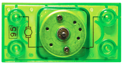 A close-up image of a green, transparent plastic component with circular holes and metal screws in the center. It appears to be part of an electronic or mechanical device, possibly a connector or sensor, featuring black circuit-like lines and numbers on the surface—reminiscent of the Circuit Blox™ - Motor Block by E-Blox®.